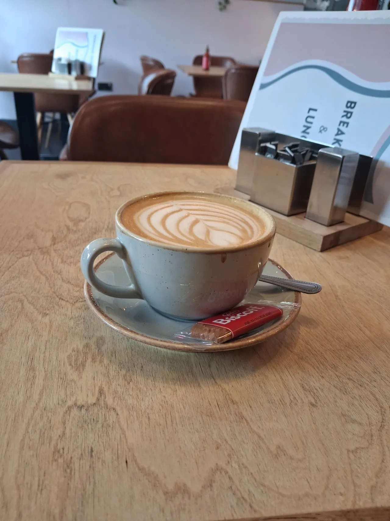 A cup of coffee on a wooden table inside the café