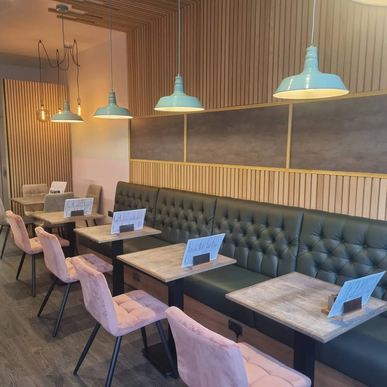 Wood-panelled walls, turquoise pendant lamps and café seating at Corner House